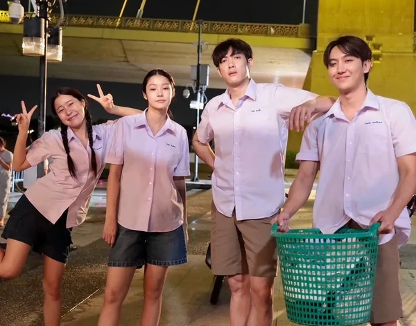 A group poses at night in "Nithan Duengdao Kwam Ruk".