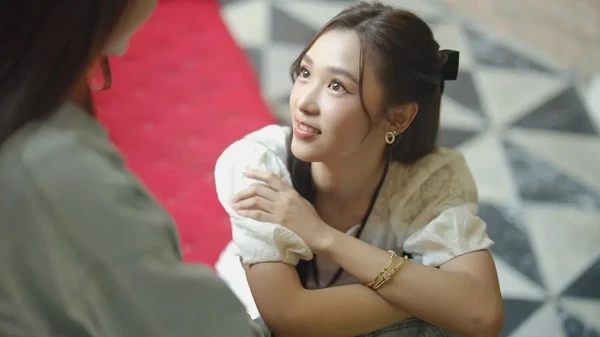 A woman looks up with a smile in "Nithan Duengdao Kwam Ruk".