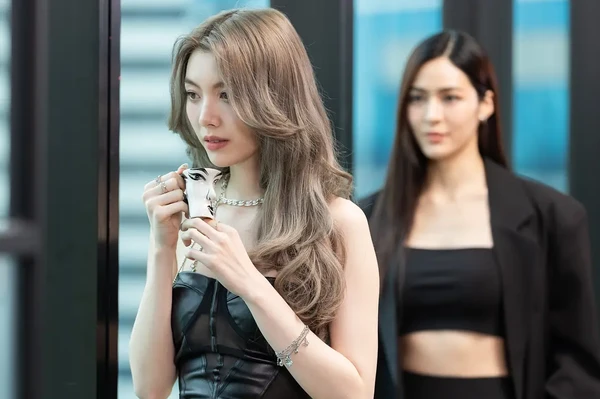 Woman drinking with another in background in "Only You".