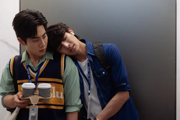 Two men in elevator, one rests head on the other in "Ossan's Love Thailand".